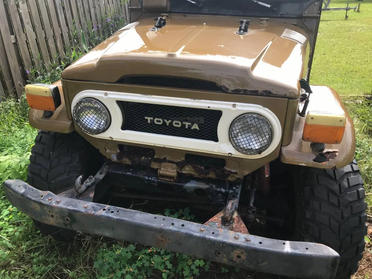 A comparison of two FJ's sitting in a yard - 79 and a 73 FJ40