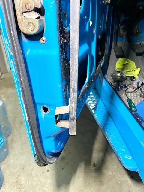 driver door lower felt bracket with large hole.webp