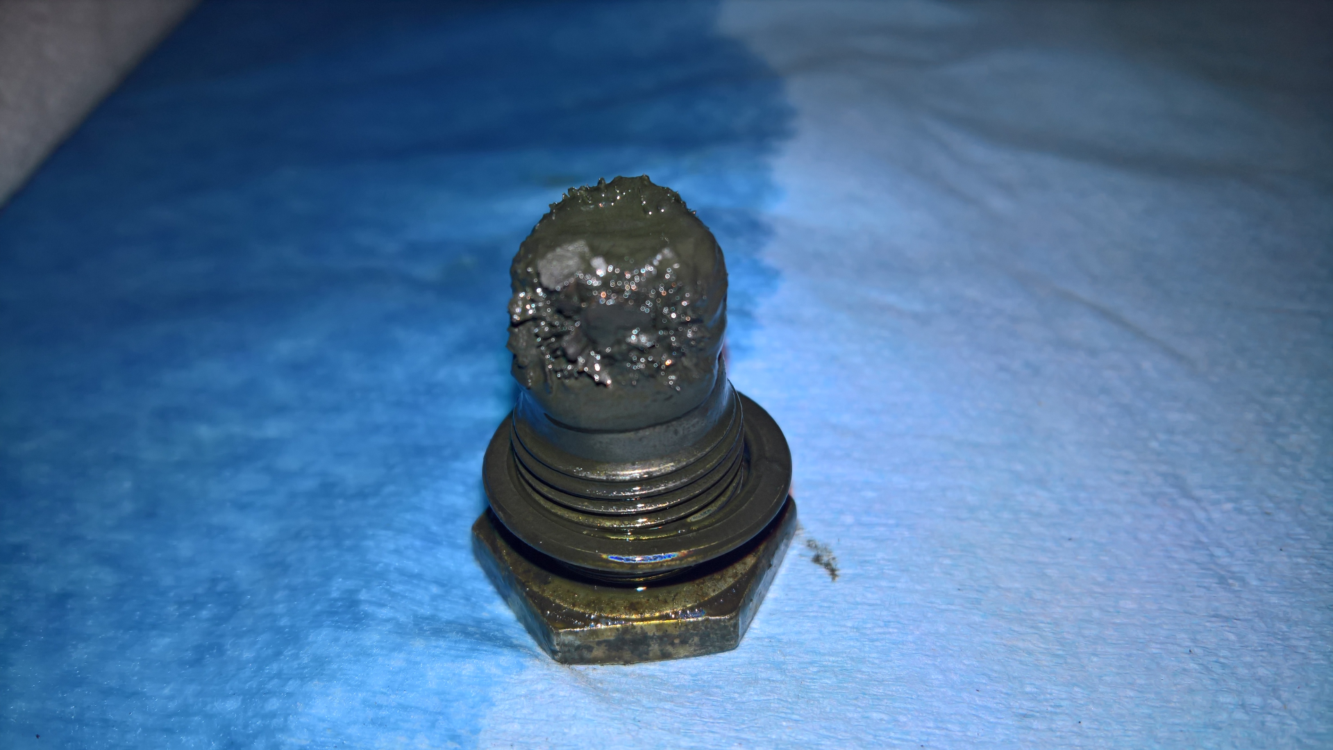 FZJ80 rear axle housing differential drain plug with rust flakes.png
