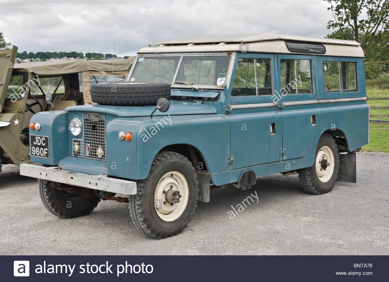 land-rover-series-ii-a-empattement-long-garee-a-cote-dune-vieille-jeep-lors-dun-rassemblement...webp