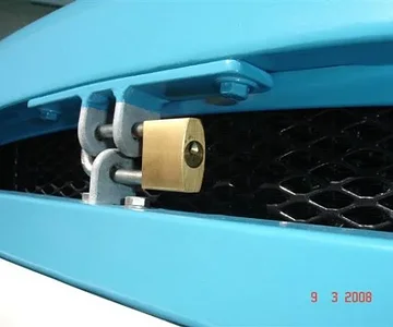 My version of a hood lock. (There's plastic tubing slipped over the padlock hoop to stop vibration noise. And the hoop is able to be removed completely from the base of the padlock - otherwise you couldn't fit the padlock!)