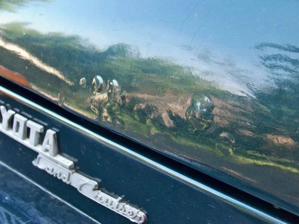There is solid evidence that this 40 was red, and a previous owner (poorly) prepped and painted it metallic green.  I popped one of these bubbles and found... rust.