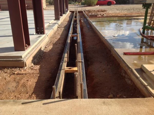 West end of building trench drain syste (formed) to rout water over flow from house scupper.